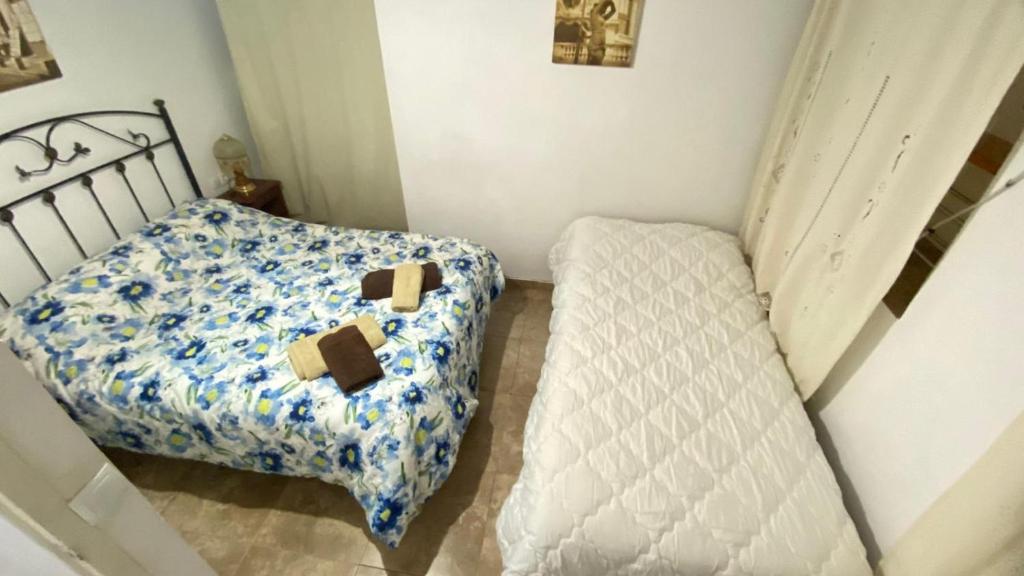 a small bedroom with a bed and a chair at Apartamento Nanda in Quesada