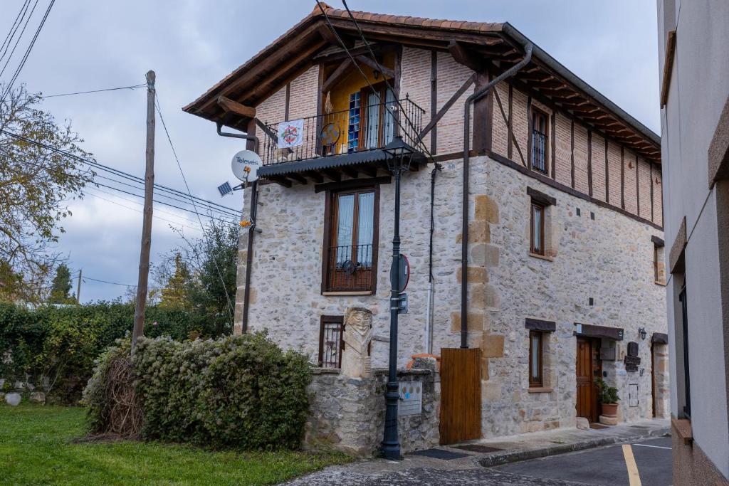 ein Steinhaus mit Balkon auf einer Straße in der Unterkunft Zadorra Etxea Casa in Salvatierra