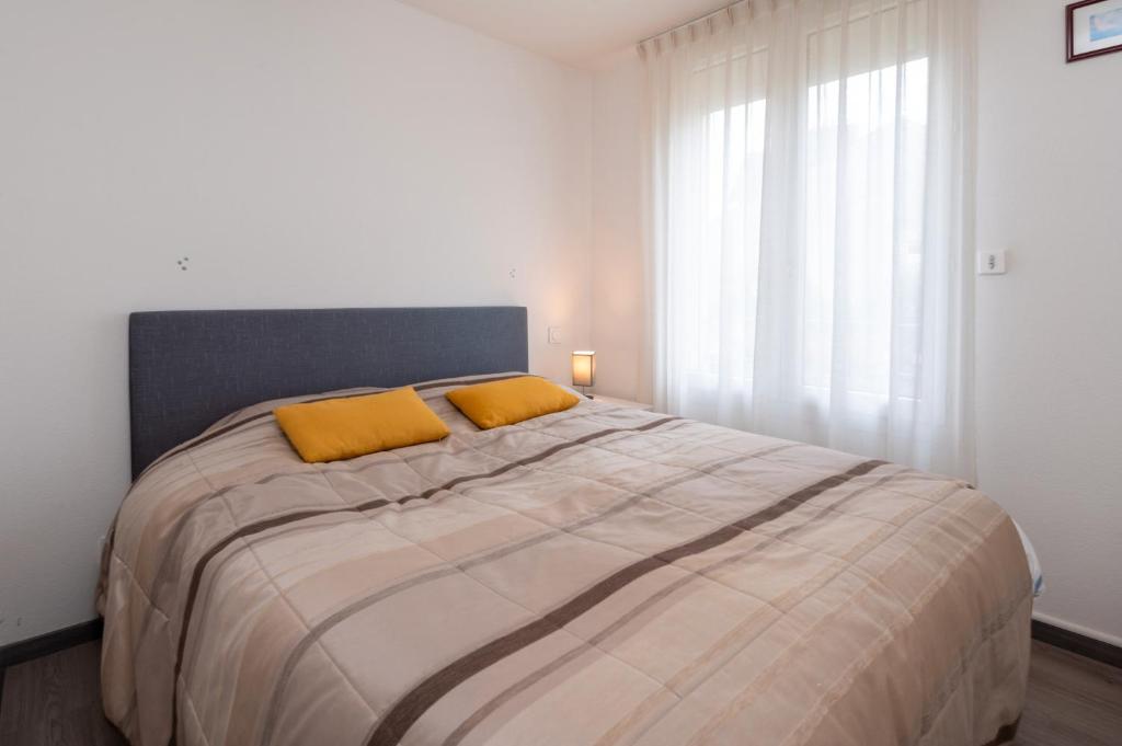 a bedroom with a large bed with two yellow pillows at Le Doumer parking wifi in Vannes