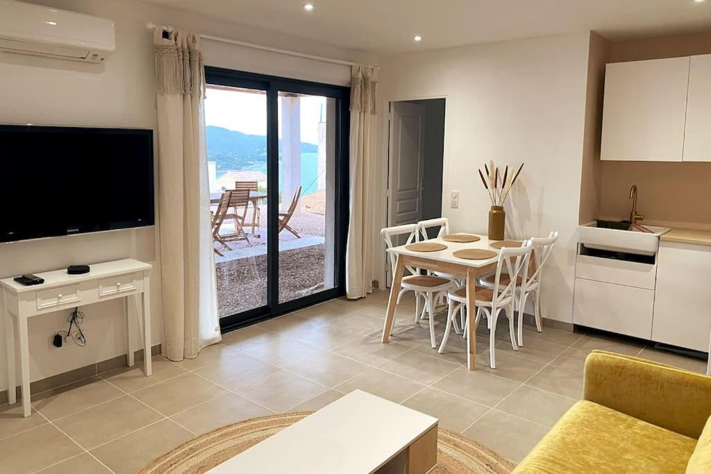 - un salon avec une cuisine et une table avec des chaises dans l'établissement Rez de villa Favone, à Conca