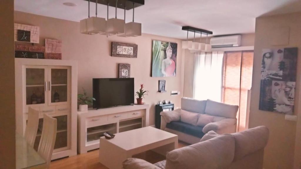 a living room with a couch and a tv at Villalucen in Lucena