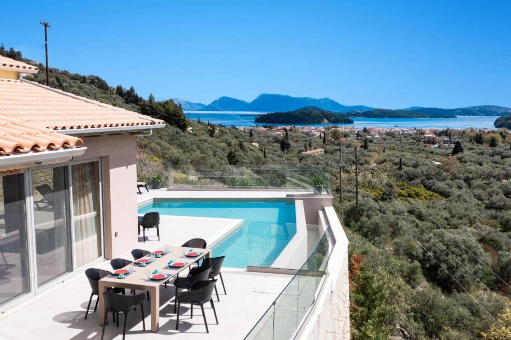 a villa with a swimming pool and a table and chairs at Villa Angelou Nidri by Villa Plus in Nydri