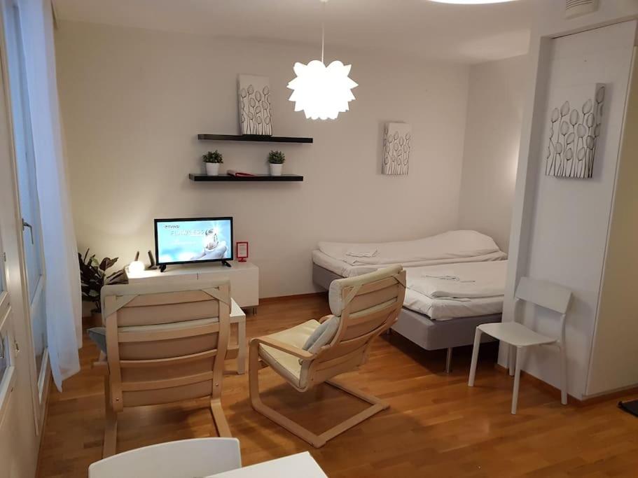 a room with a desk with a computer and a bed at Kotimaailma - Studio with sauna in center in Turku