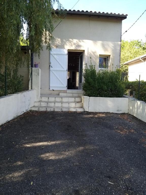 une maison blanche avec un portail et une allée. dans l'établissement Maison prés d'Agen, à Bon-Encontre