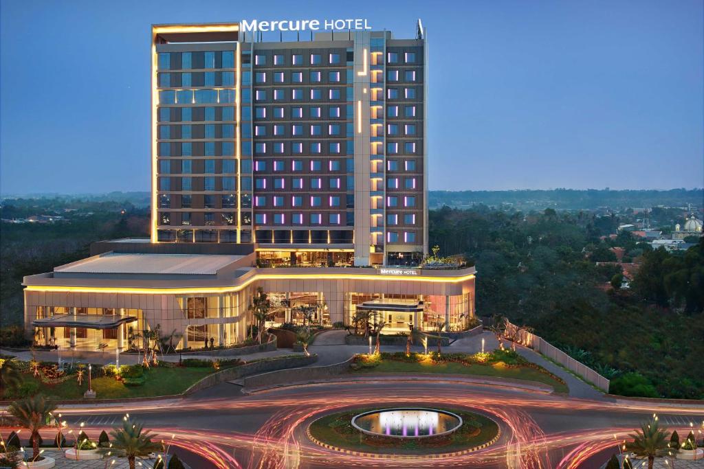 a hotel with a large building in front of a freeway at Mercure Karawang in Karawang