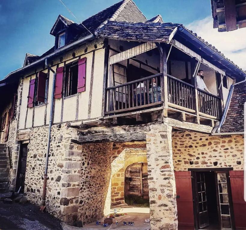 Cette maison ancienne possède un balcon avec deux chiens. dans l'établissement Le Battut, à Beaulieu-sur-Dordogne
