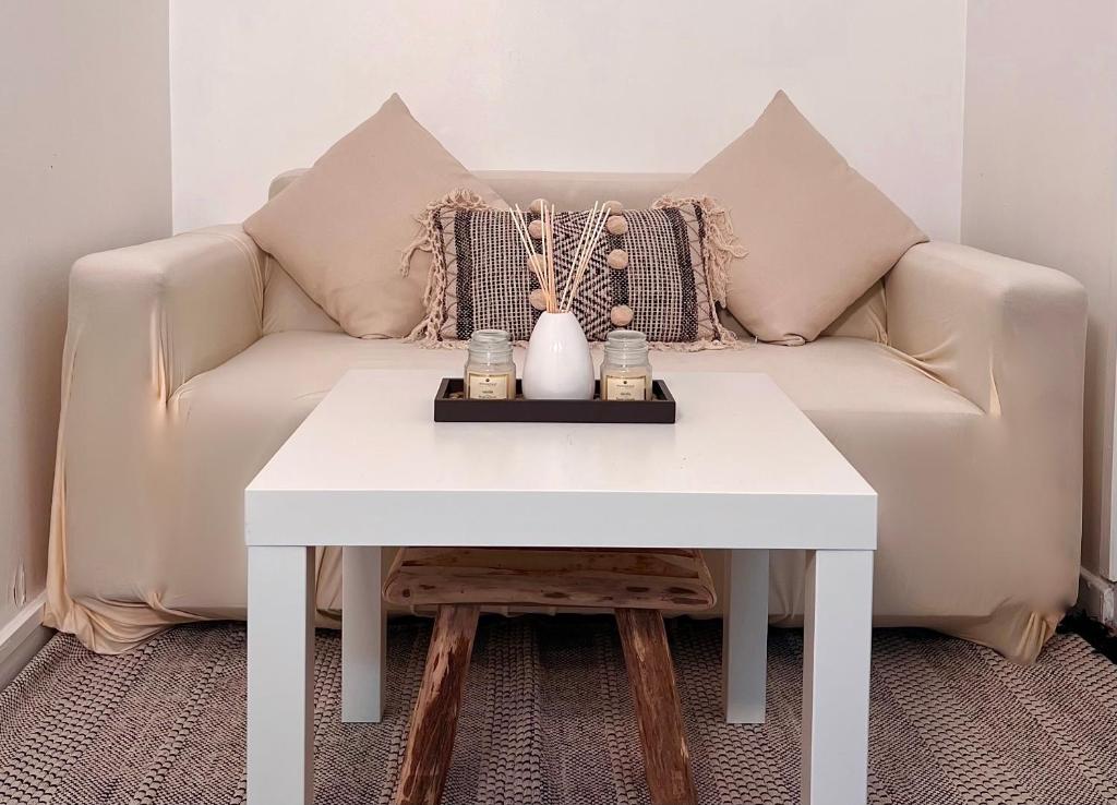 sala de estar con sofá y mesa blanca en Studio Saint Denis, en Saint-Denis