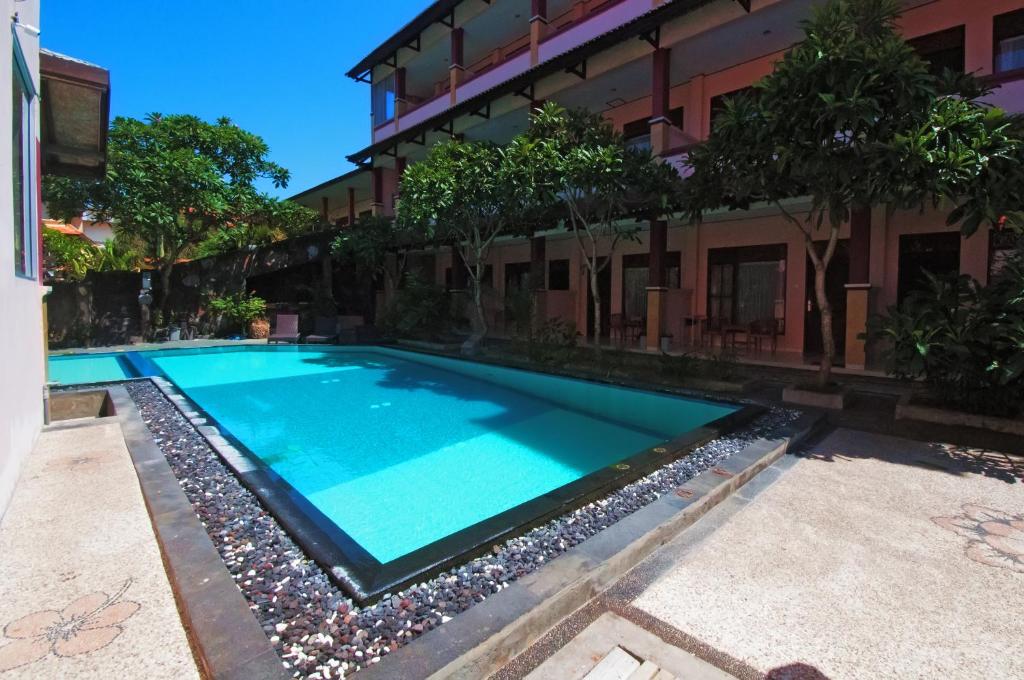a swimming pool in front of a building at Pesona Beach Inn in Kuta