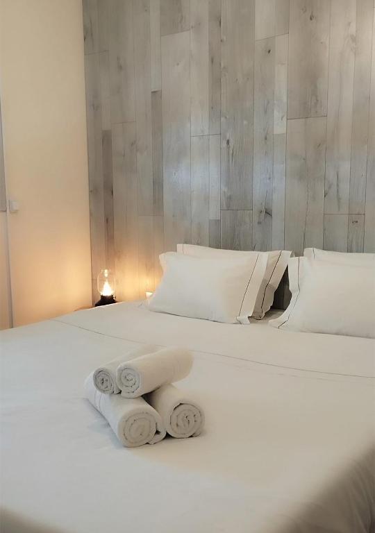 a white bed with two rolled towels on it at Oportocean Suites in Matosinhos