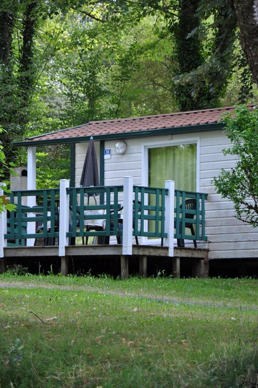 une cabine avec des bancs verts et une clôture dans l'établissement Les Chalets Du Moulin Du Châtain 2, à Payzac