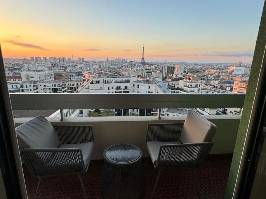 a balcony with two chairs and a view of a city at Montparnasse - Vue Tour Eiffel - Balcon in Paris