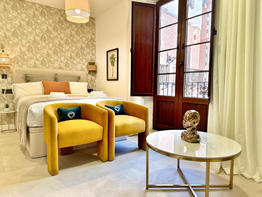 een slaapkamer met een bed, een tafel en een stoel bij Tennessee Petit Málaga in Málaga