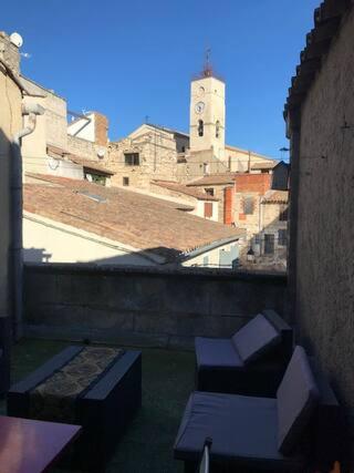 - un balcon avec 2 chaises et une tour d'horloge dans l'établissement Chambre,Salle de bain,Terrasse, à Saint-Gilles