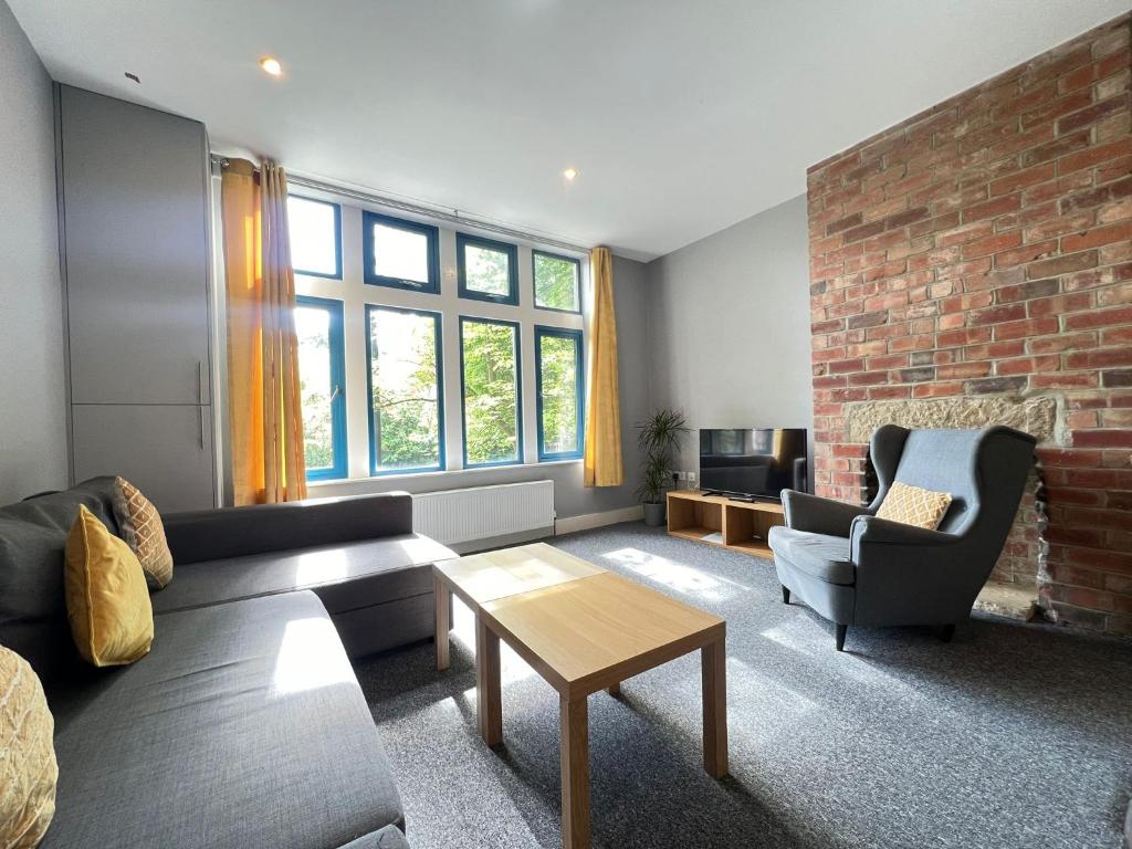 a living room with a couch and a brick wall at 1 bed Apt close to Leeds Arena Sleeps up to 4 people F3 in Leeds