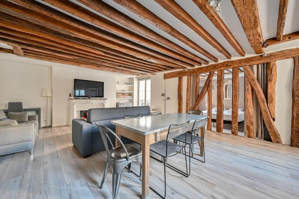 un salon avec une table et un canapé dans l'établissement Grand 2 pieces typique du Marais - FLAT-GUEST, à Paris