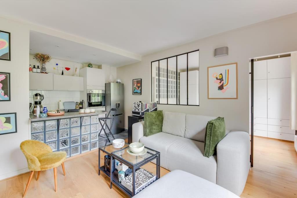 un salon avec un canapé et une table dans l'établissement Bel appartement 2 pièces place de la République 75011, à Paris