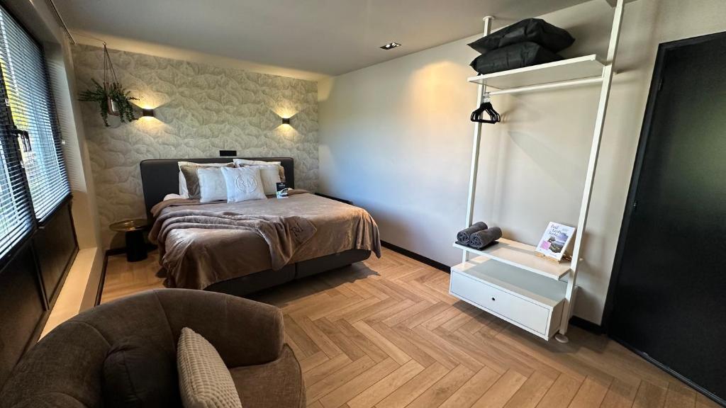 een kleine slaapkamer met een bed en een stoel bij Boutique Hotel Le Faucon in Valkenburg
