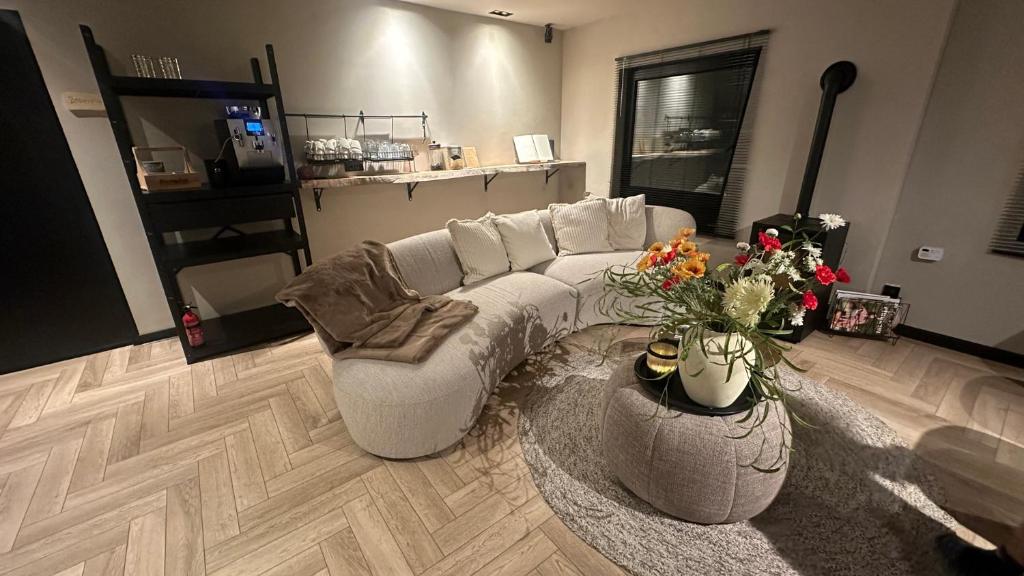 een woonkamer met een witte bank en bloemen bij Boutique Hotel Le Faucon in Valkenburg