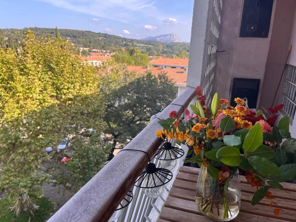 un vase rempli de fleurs assis sur un balcon dans l'établissement Calme, vue st Victoire, proche centre ville avec parking, à Aix-en-Provence
