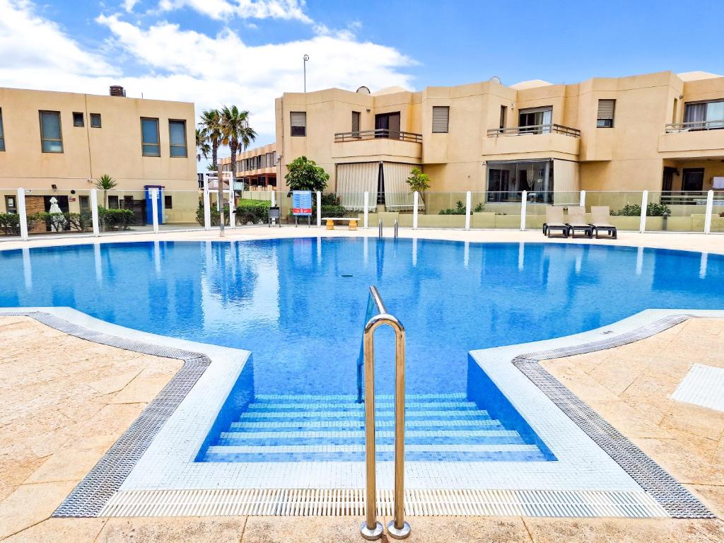 a large swimming pool with stairs in front of buildings at La Tejita - Family Apartment Home in La Mareta