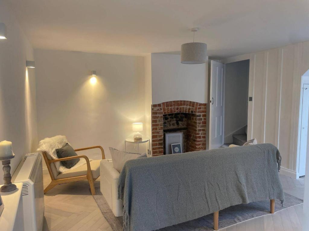 - un salon avec un lit et une cheminée dans l'établissement Seaside Retreat - Sleeps 5 garden & parking, à Cromer