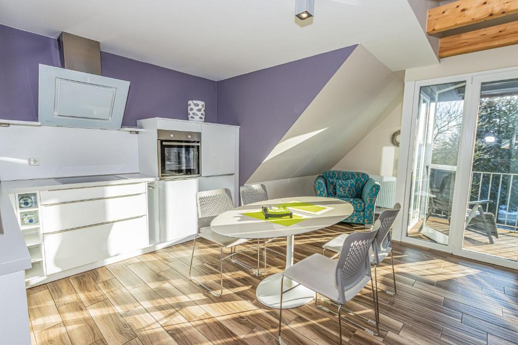 cocina con paredes de color púrpura, mesa y sillas en Ferienwohnung Küstenhaus, en Esens