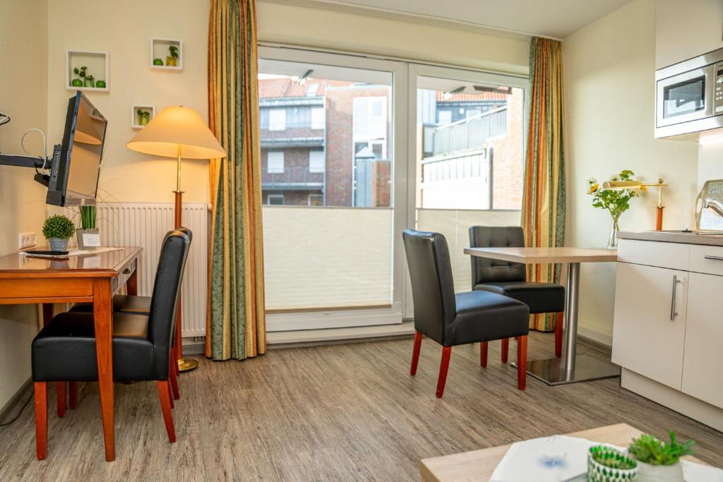 an apartment with a kitchen and a table and chairs at Apartment Juwel in Bensersiel