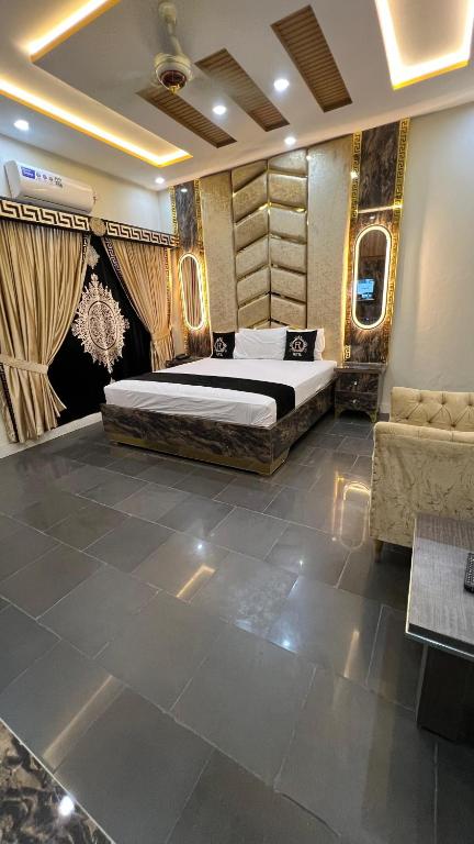 a bedroom with a large bed and a couch at Hotel new royal palace in Lahore