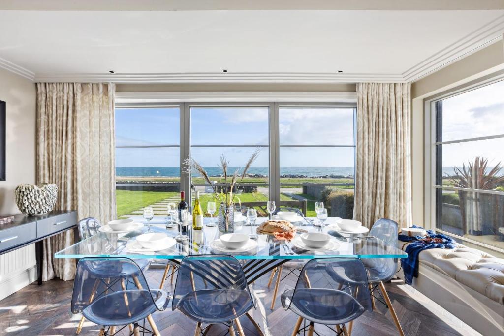 a dining room with a table and chairs and a large window at Beam Ends - Beachfront House, Parking, Allows Pet in Beesands