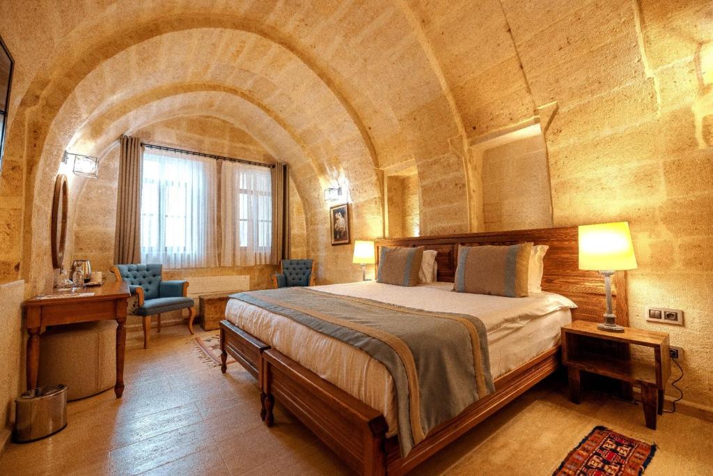 een slaapkamer met een groot bed in een grote kamer bij Misty Cave Hotel in Urgup
