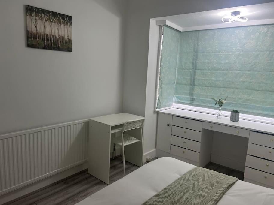 une chambre avec un lit, un bureau et une fenêtre dans l'établissement 4 Bedroom semi detached House London, à Edgware