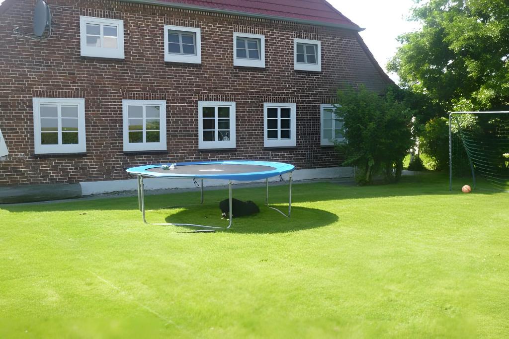 a table in the grass in front of a brick building at Fewo Nissen Dagebüll in Dagebüll