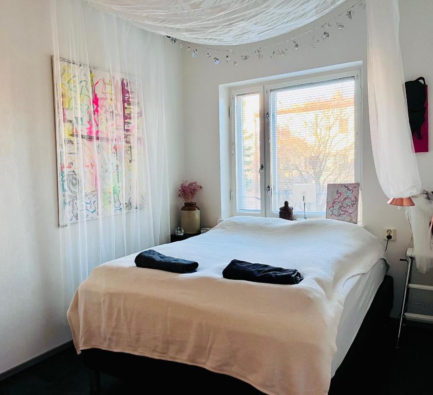a bedroom with a large white bed with a window at Cozy Condo in Käpylä in Helsinki