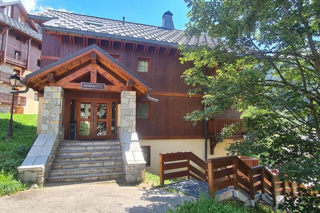 un bâtiment avec une porte et deux bancs devant lui dans l'établissement Appartement 4 ou 5 pers ambiance montagne, à Oz