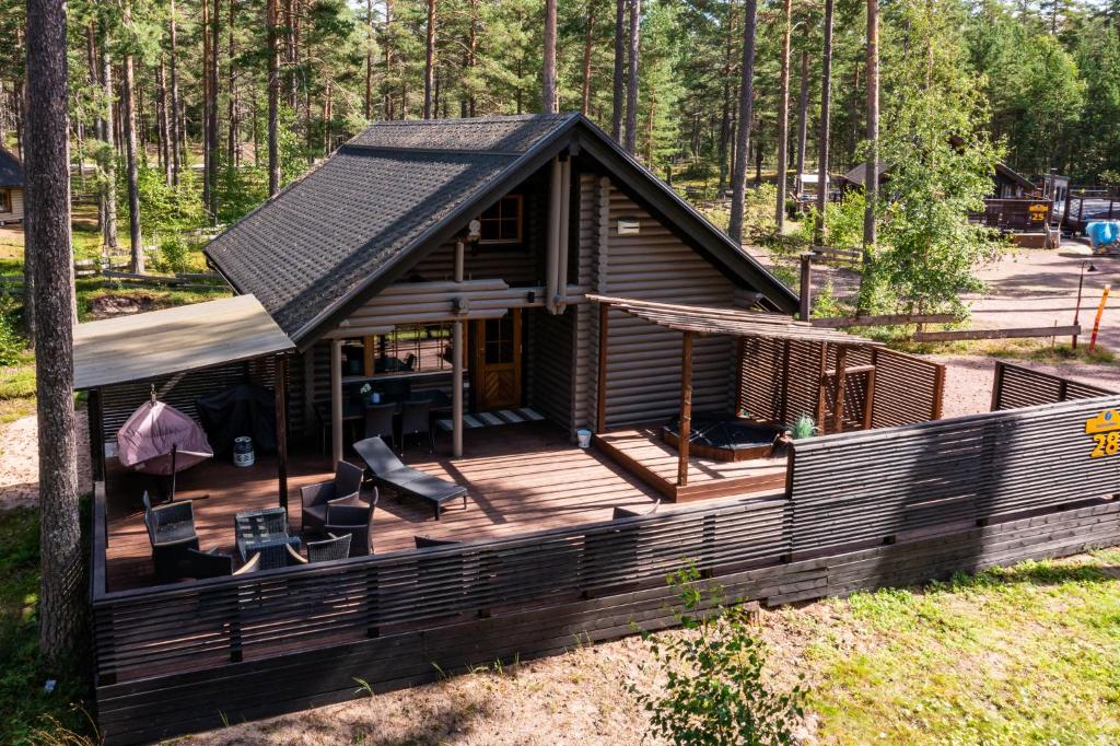 a cabin in the woods with a large wooden deck at Yyteri Beach Lomakeskus, Havulinna 28 in Pori