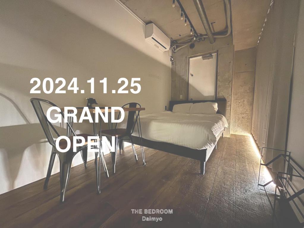 Ein Schlafzimmer mit einem Bett und einem Tisch mit einem Schild, auf dem „Großer Tag der offenen Tür“ steht. in der Unterkunft THE BEDROOM Daimyo in Fukuoka
