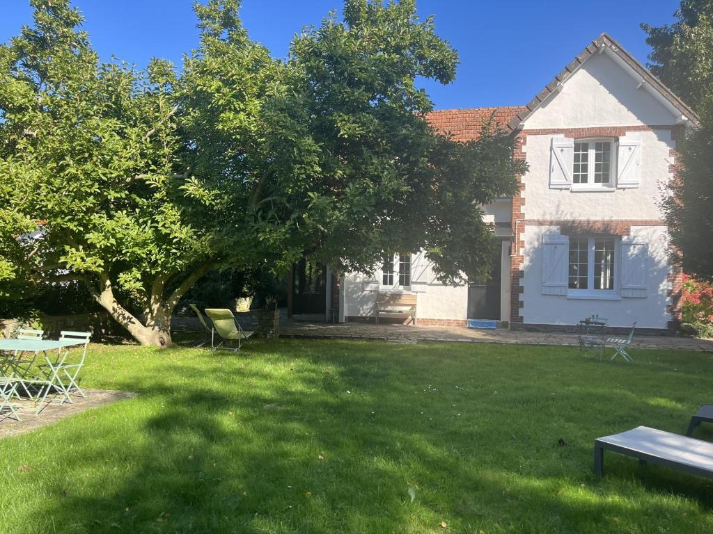 une maison avec une cour avec une table et des chaises dans l'établissement Six hetres, à Varengeville-sur-Mer