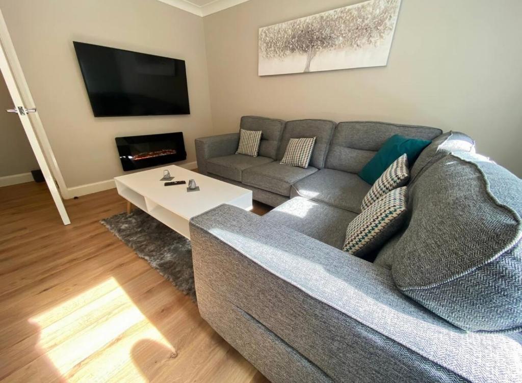 una sala de estar con un sofá y una mesa en Central two bedroom, Free private parking, en Glasgow