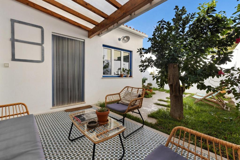 a patio with a table and chairs and a tree at Casa das Cantonas Valada in Valada