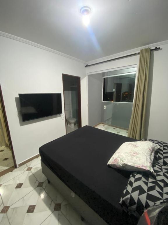 una camera da letto con un letto e una grande finestra di Pedreira baixa a Ubatuba