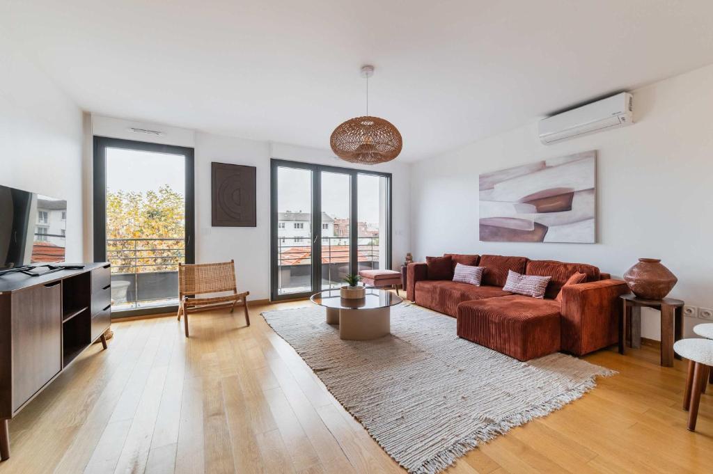 un salon avec un canapé et une télévision dans l'établissement Duplex lumineux avec terrasse Courbevoie - 6P - FLAT-GUEST, à Courbevoie