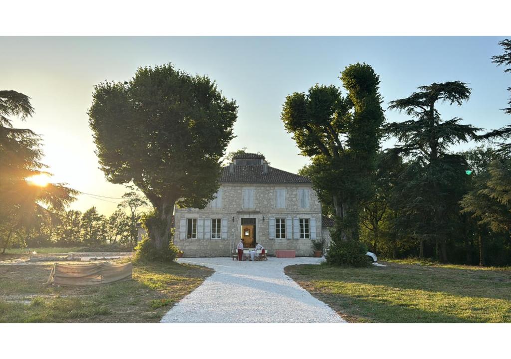 a large white house with trees in front of it at Secluded manoir in SW France in Lamontjoie