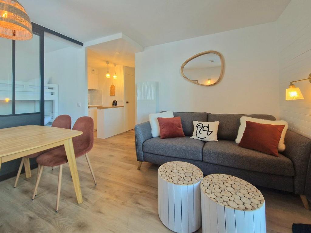 un salon avec un canapé, une table et des chaises dans l'établissement Le Croix Du Sud - 2050m La Plagne F2 Vue montagne, à La Plagne Tarentaise