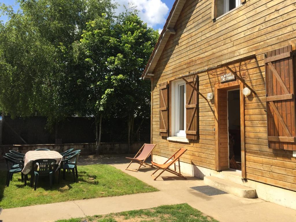 a patio with a table and chairs next to a house at LA BELLE ETOILE in Auneau