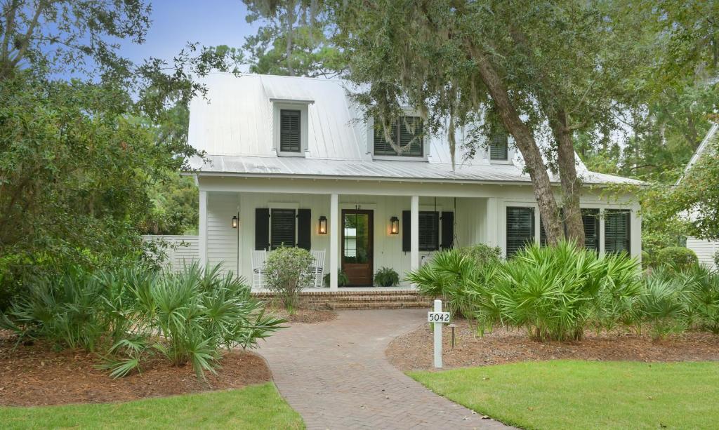 a white house with black shutters at 4 Bedroom Wilson Village Home 5042 in Bluffton