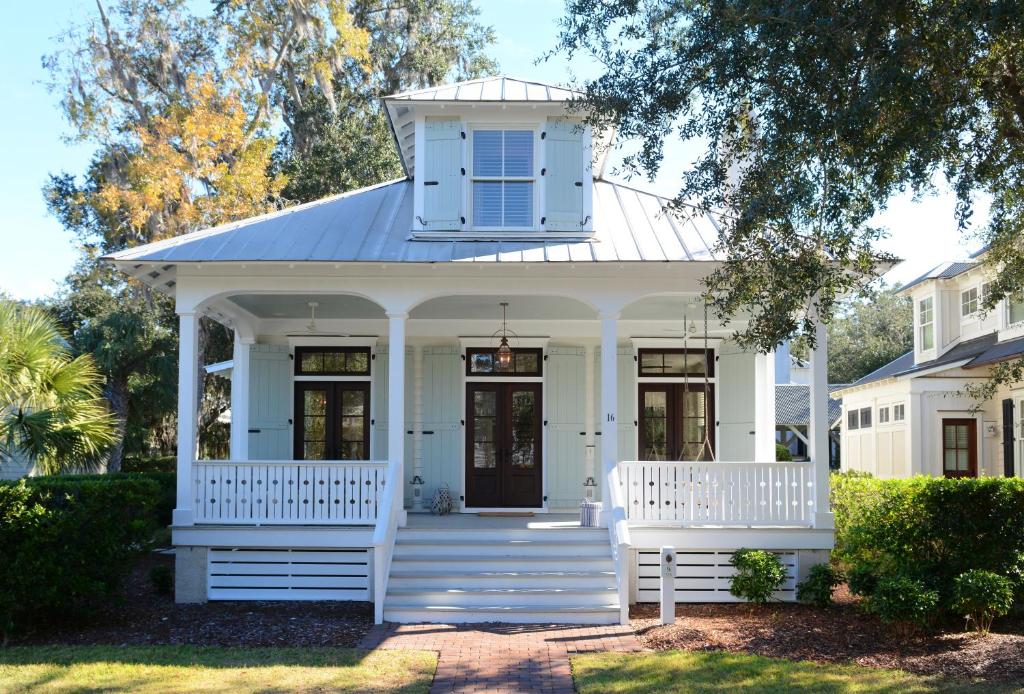 a white house with a white porch and a door at 4 Bedroom Wilson Village Home 6 in Bluffton
