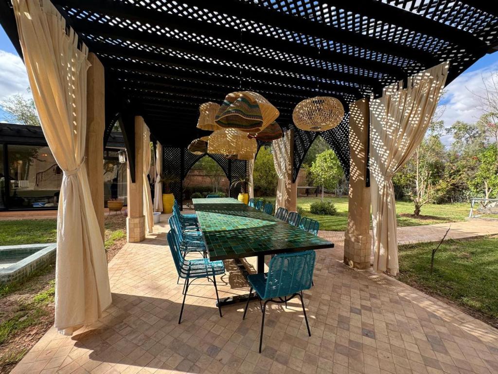 a table and chairs under a pergola with a table and chairs at Villa Ania in Marrakesh