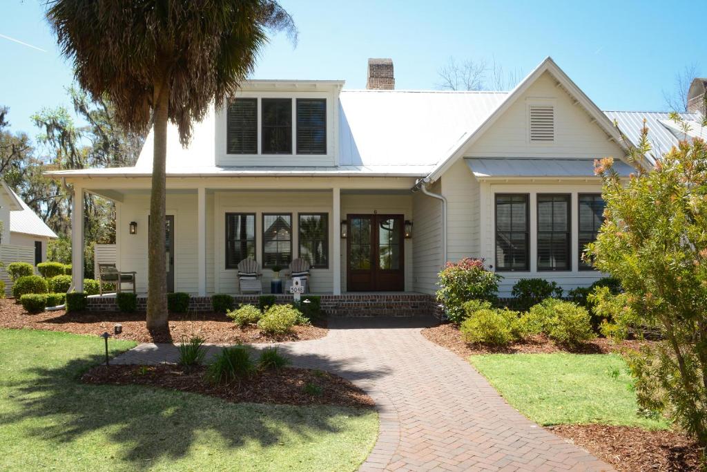 a house with a palm tree in the front yard at 5 Bedroom Wilson Village Home 5048 in Bluffton