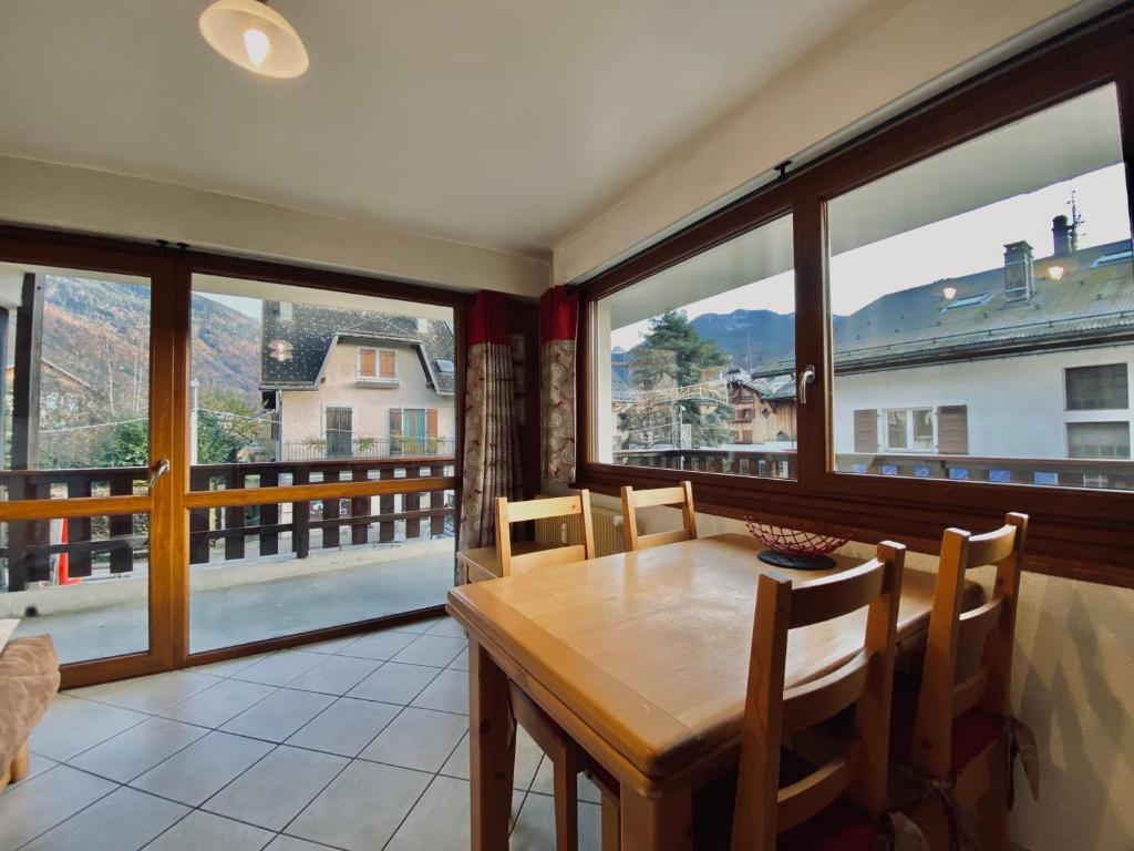 d'une salle à manger avec une table et quelques fenêtres. dans l'établissement Charmant T2 au cœur de Samoëns avec balcon, proche commerces et ski-bus - FR-1-624-44, à Samoëns