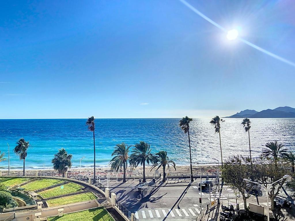 une vue sur une plage avec des palmiers et l'océan dans l'établissement Très jolie vue mer et emplacement idéal - 243L RIV, à Cannes